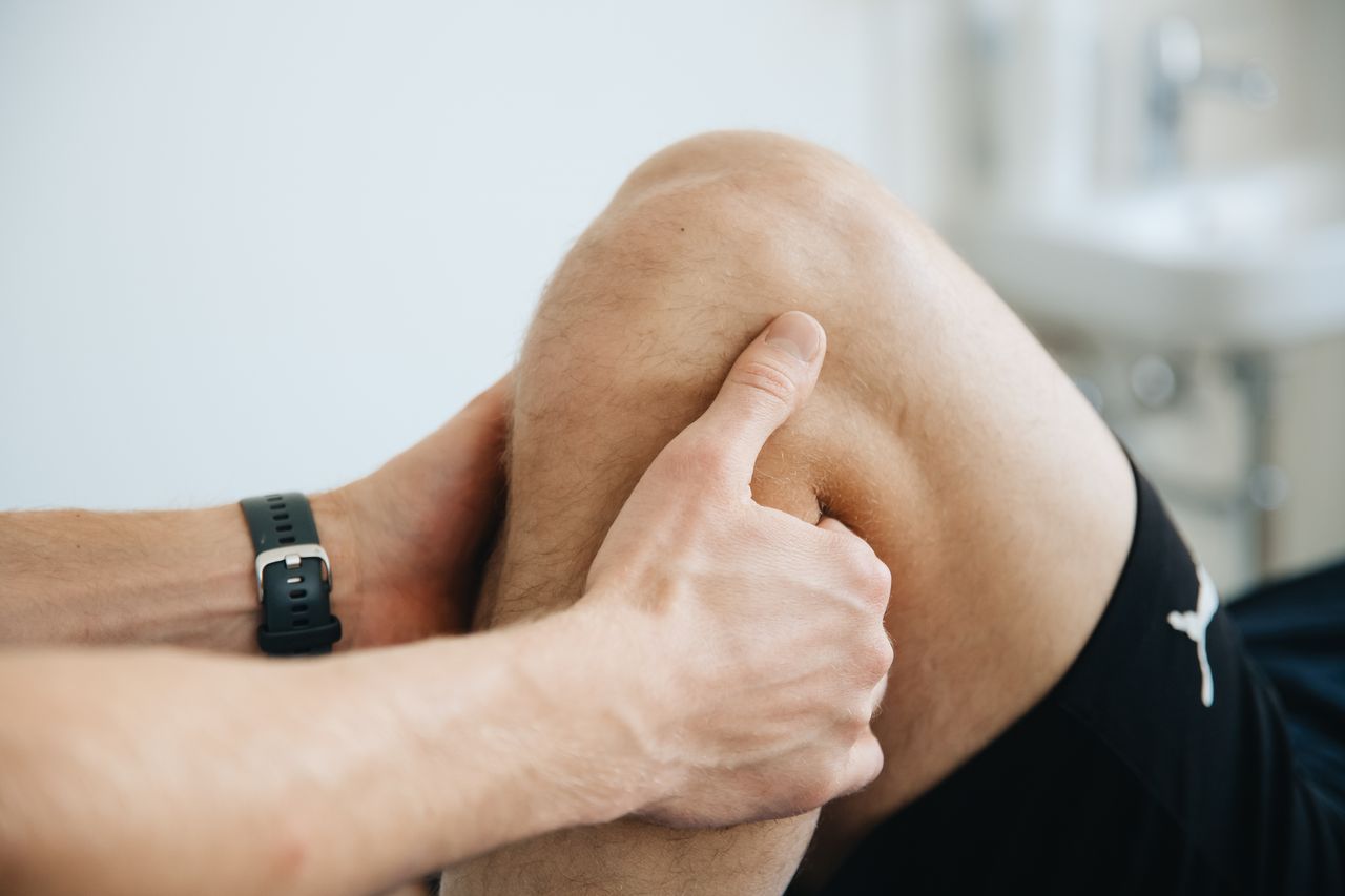 The Art of Drawing Readers In: Your attractive post title goes here Close-up of a physiotherapist massaging a patient's knee during therapy.